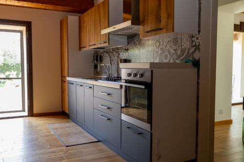 a kitchen with white cabinets and a stove top oven at Oasi mandrevecchie in Giarratana