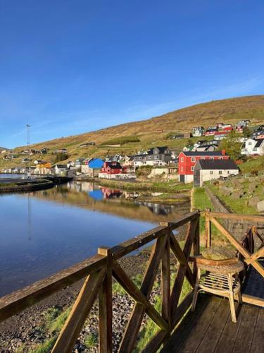 un pont en bois sur un plan d'eau avec une ville dans l'établissement Cottage by the waterfront, à Vestmanna