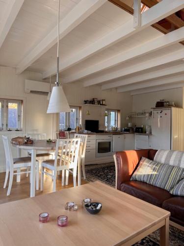 une cuisine et un salon avec une table et un canapé dans l'établissement Cottage by the waterfront, à Vestmanna