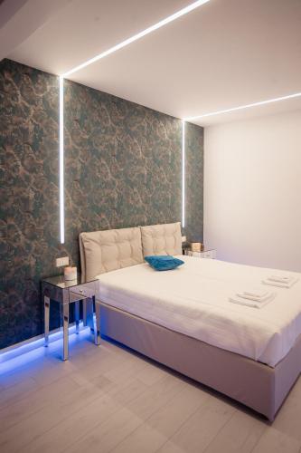 a bedroom with a large bed and a wall at Suite La PerlaNera- TorreCanne in Torre Canne
