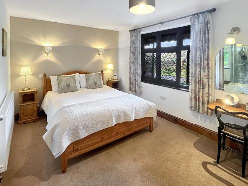 a bedroom with a large bed and a window at Chauffeur’s Cottage Martinhoe in Martinhoe