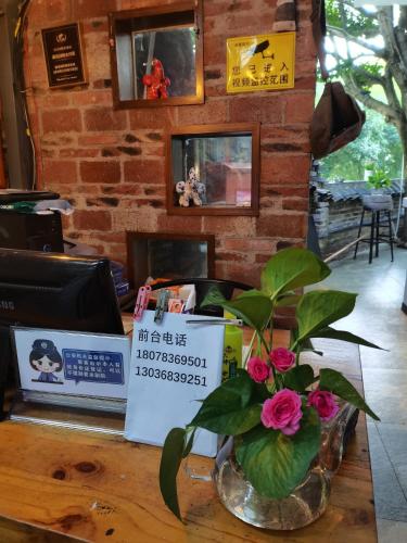 a table with a vase with flowers on it at XiXi Lakeside Inn in Guilin