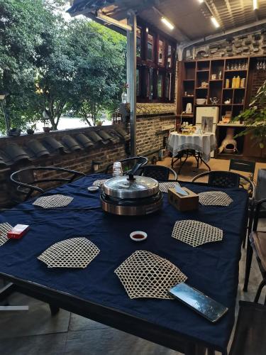 a table with a blue table cloth with a pot on it at XiXi Lakeside Inn in Guilin