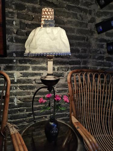 a table with a lamp and some flowers on it at XiXi Lakeside Inn in Guilin