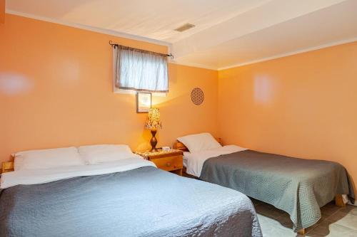 duas camas em um quarto com paredes laranja em Fresh Private Apartment Lower level- 2 beds em Brampton