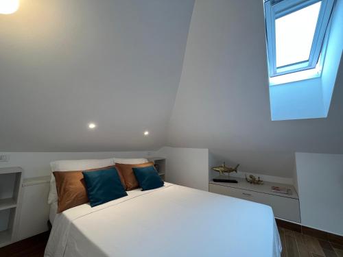 a bedroom with a large white bed with blue pillows at Casa Monnalisa - Calandre Sabbie Oro in Ventimiglia