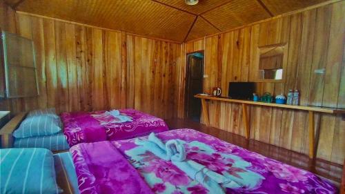 a bedroom with a bed with a purple blanket at Mukakee in Ban Sop Mae Klang
