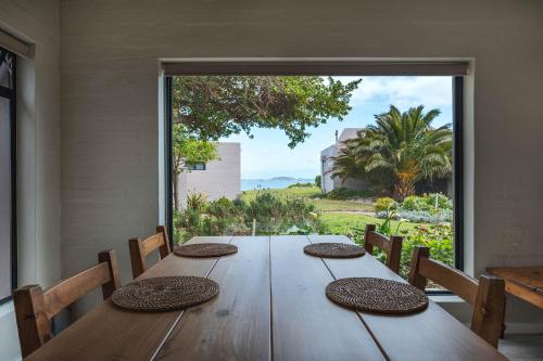a dining room with a table and a large window at Blue Bay Lodge in Saldanha