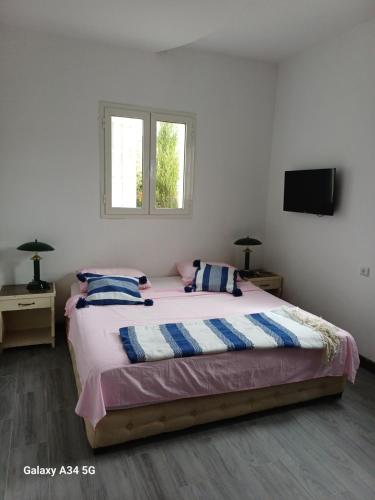 a bedroom with a large bed with two pillows at Dar redouane in El Jadida