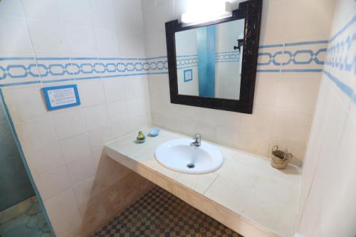 a bathroom with a sink and a mirror at Paradis Nomade in Azrarag