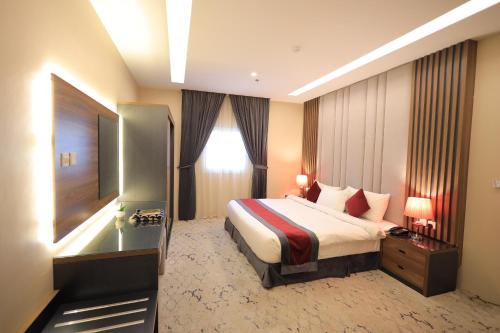 a hotel room with a bed and a window at الريد فال للشقق المخدومة in Jeddah