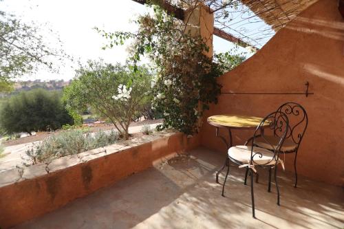 a table and chairs sitting on a patio with a window at Paradis Nomade in Azrarag