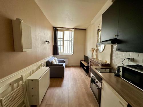 une cuisine et un salon avec un canapé et une table dans l'établissement Le Charmant Vannerie, à Dijon