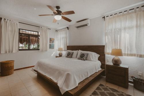 une chambre avec un lit et un ventilateur de plafond dans l'établissement Casa La Buena Vida 2 bedroom Villa, à Puerto Morelos