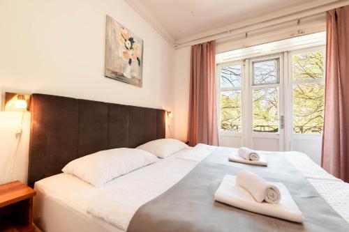 a bedroom with a large bed with two towels on it at Penzion Pod Lipo in Ljubljana