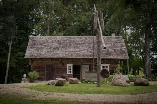 a log cabin with rocks in front of it at An authentic granary in Bilioniai
