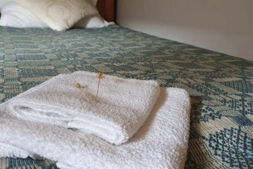 a white towel sitting on top of a bed at An authentic granary in Bilioniai