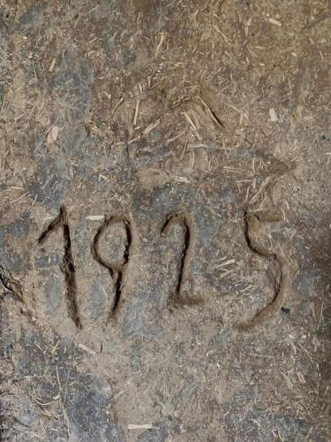 a word written in the sand on the ground at An authentic granary in Bilioniai