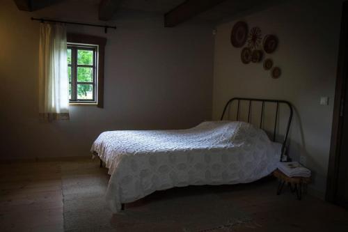 a bedroom with a bed and a window at An authentic granary in Bilioniai