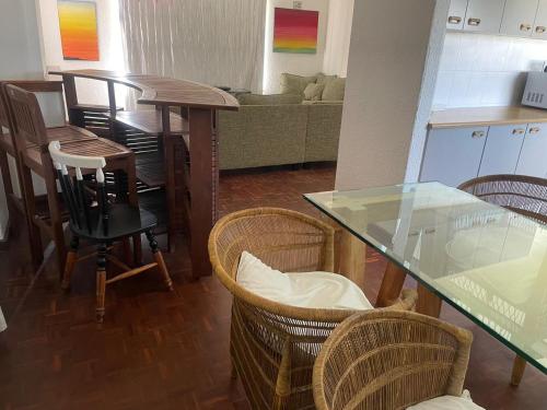a kitchen and dining room with a glass table and chairs at House on Gill 2 in Cape Town