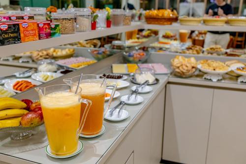 a buffet line with two glasses of orange juice at Hotel Villa de Holanda in Holambra