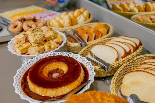 a table topped with different types of pastries and pies at Hotel Villa de Holanda in Holambra