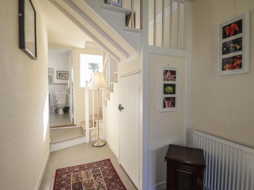 a hallway with a stairway with a door and a rug at Rarsaidh in Arnisdale