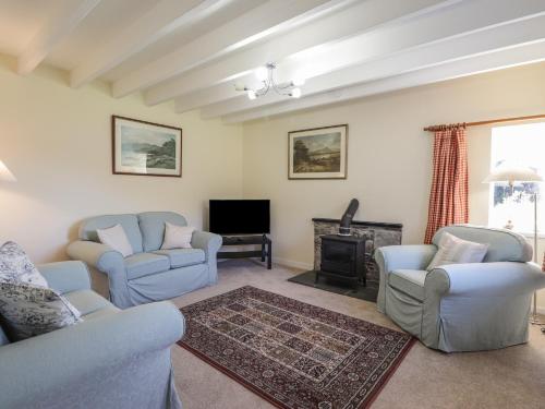 a living room with two chairs and a fireplace at Rarsaidh in Arnisdale