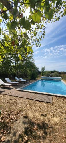 une piscine avec des chaises longues à côté dans l'établissement Une maison de famille dans le Luberon, à Bonnieux
