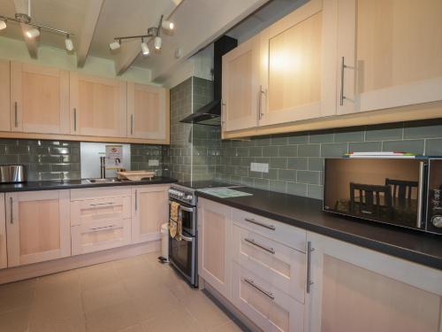 a large kitchen with wooden cabinets and appliances at Rarsaidh in Arnisdale