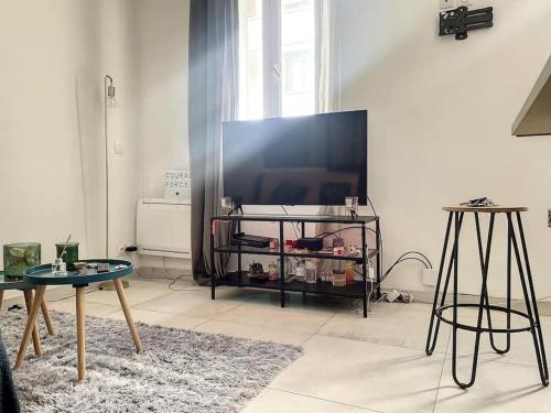 un salon avec une grande télévision à écran plat dans l'établissement Studio bord de plage - Mourillon, à Toulon