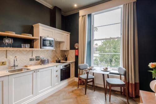a kitchen with a table and chairs and a window at Tyndall's Park - Your Apartment in Bristol