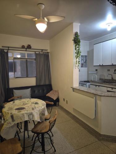 a living room with a table and a kitchen at Predio frente a praia ap 615 in Praia Grande