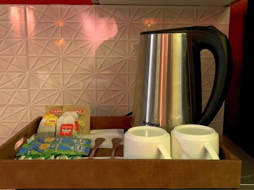 a wooden tray with a coffee pot and cups at Royal Reside by StayMehman in Rawalpindi