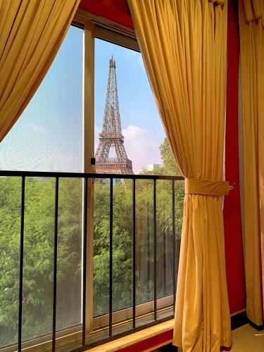 a window with a view of the eiffel tower at Royal Reside by StayMehman in Rawalpindi