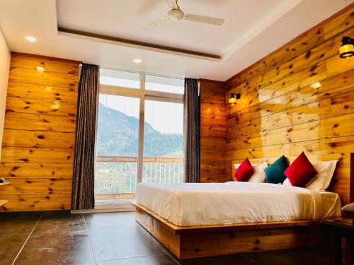 a bedroom with a bed and a large window at The Crown in Dharamshala