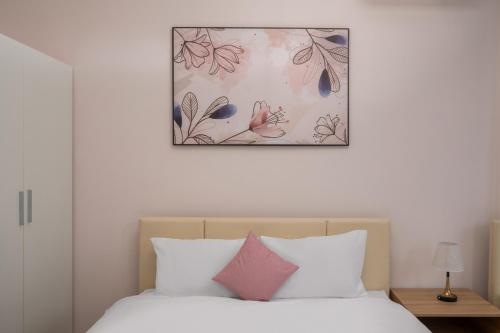 a bedroom with a bed with a picture above it at Phê Hotel in Da Nang