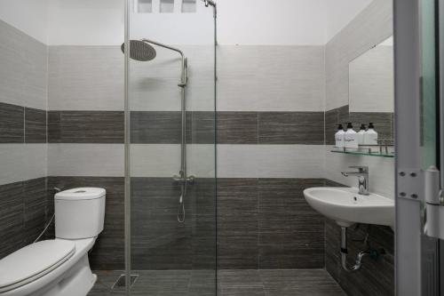 a bathroom with a shower and a toilet and a sink at Phê Hotel in Da Nang