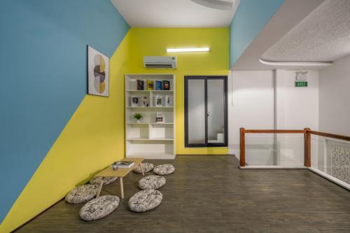 a room with colorful walls and a bench and rocks at Phê Hotel in Da Nang