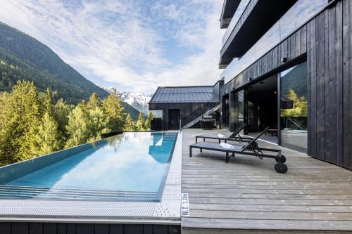 a house with a swimming pool in the mountains at Paznauner Villen - Villa I in Kappl