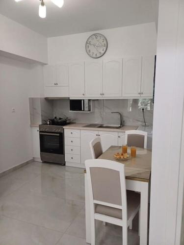 a kitchen with a table and chairs and a clock at Filocsenia sea side in Tsoutsouros