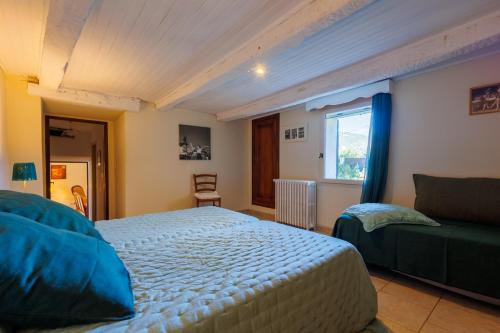 une chambre avec un lit et un canapé dans l'établissement Le Viguier - Maison avec terrasse vue montagne, à Monieux