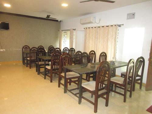 a group of tables and chairs in a room at KSTDC Hotel Mayura Velapuri Belur in Belūr