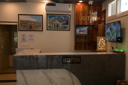 RudraprayāgにあるHotel Udit Inn Rudraprayagの壁掛けのカウンターとポスター付きの部屋