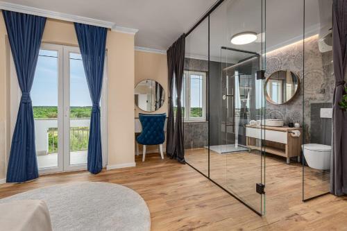 a bathroom with a glass shower and a blue chair at Villa Lea ZadarVillas in Zaton