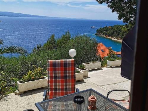 a table and a chair with a view of the ocean at Apartments Duro in Stanići