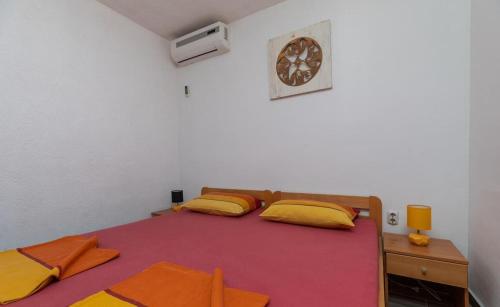 a bedroom with two beds and a clock on the wall at Apartments Duro in Stanići