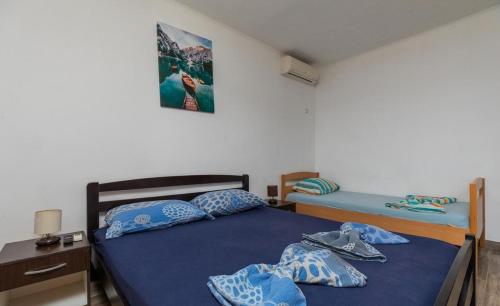 a bedroom with two beds with blue sheets and shoes at Apartments Duro in Stanići
