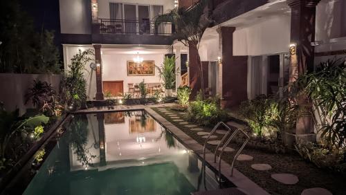 a house with a swimming pool at night at Sujiwa Ubud Hotel & Villa in Ubud