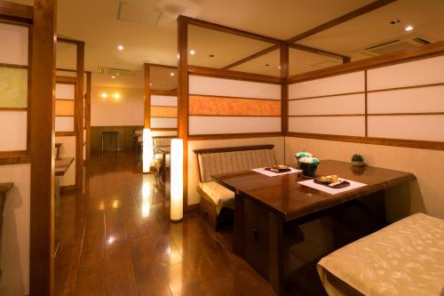 a room with a table and a bed in it at Dogo Grand Hotel in Matsuyama